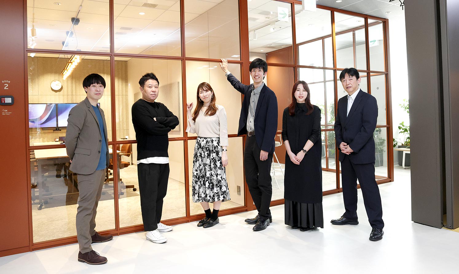 パーティションの前に並ぶプロジェクトメンバー