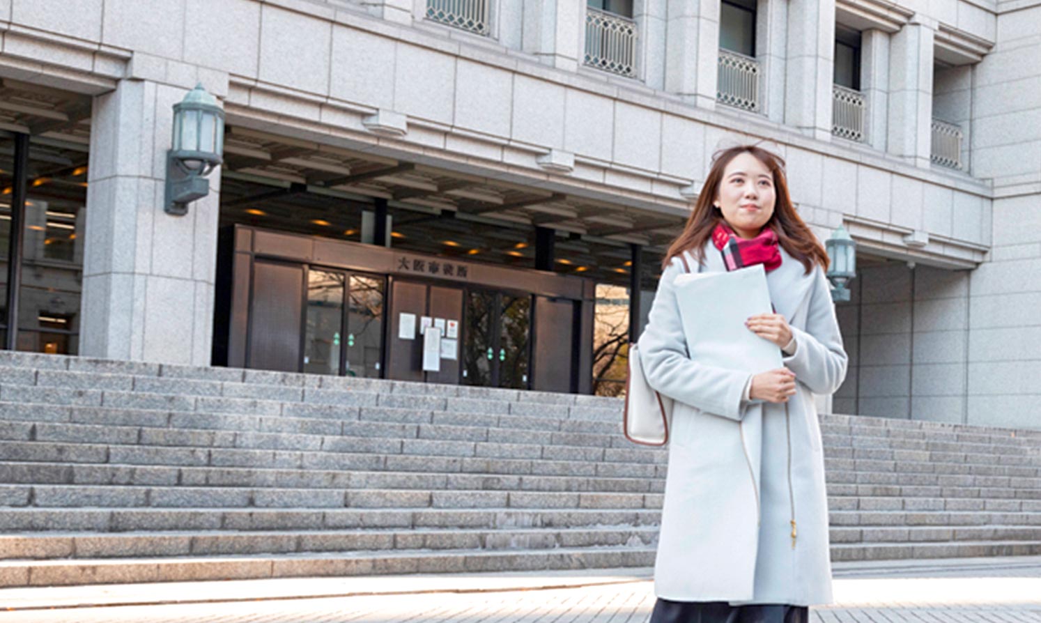 溝口 夏海 屋外で書類を抱えている